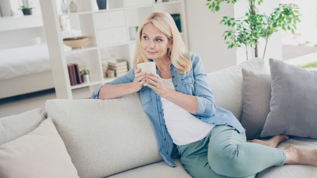Woman Holding A Mug Sitting In A House Couch