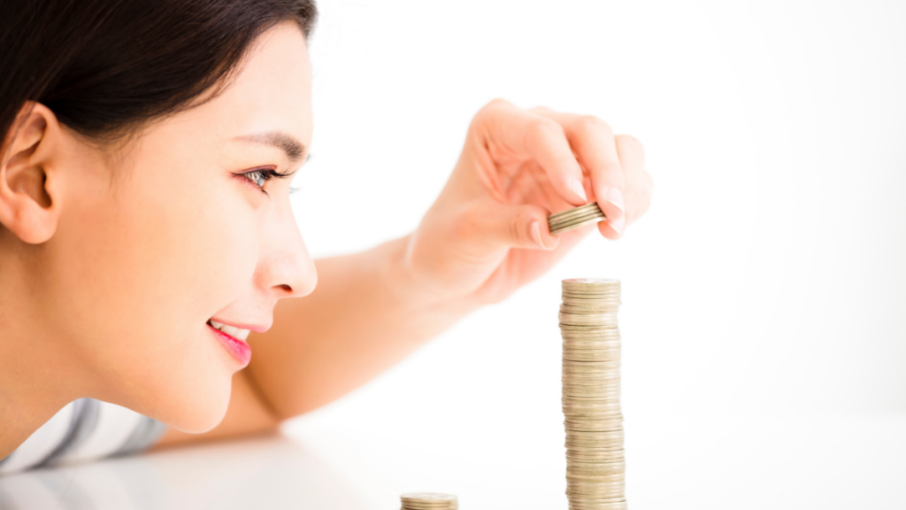 Young Woman Putting Coins into a Stack