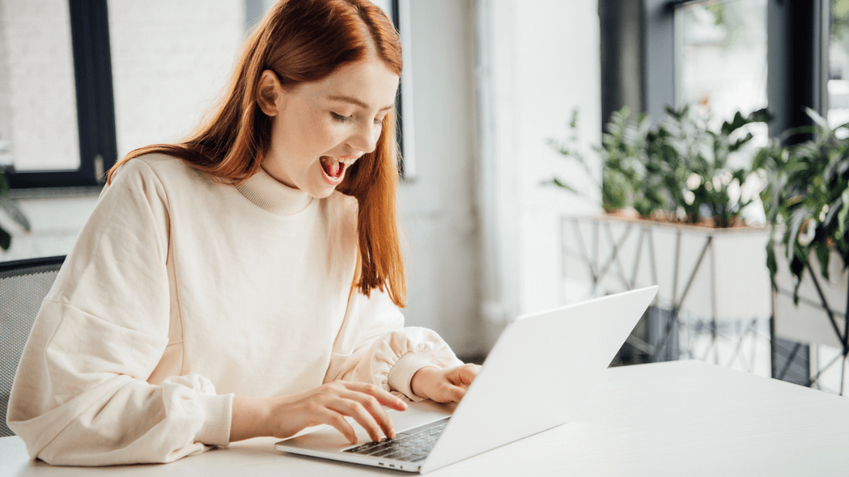 Person enjoying financial activity on laptop