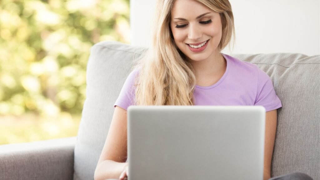 Woman Smiling While Typing On Her Laptop MSN