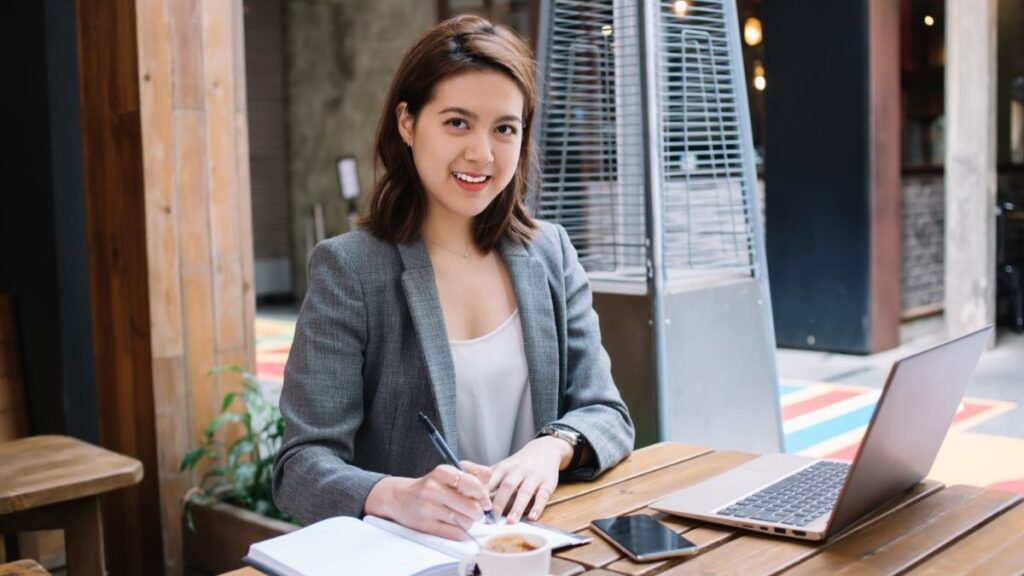Woman smiling while writing in a notebook