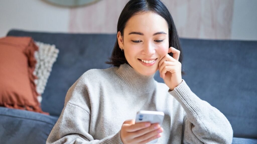 Woman using phone and smiling