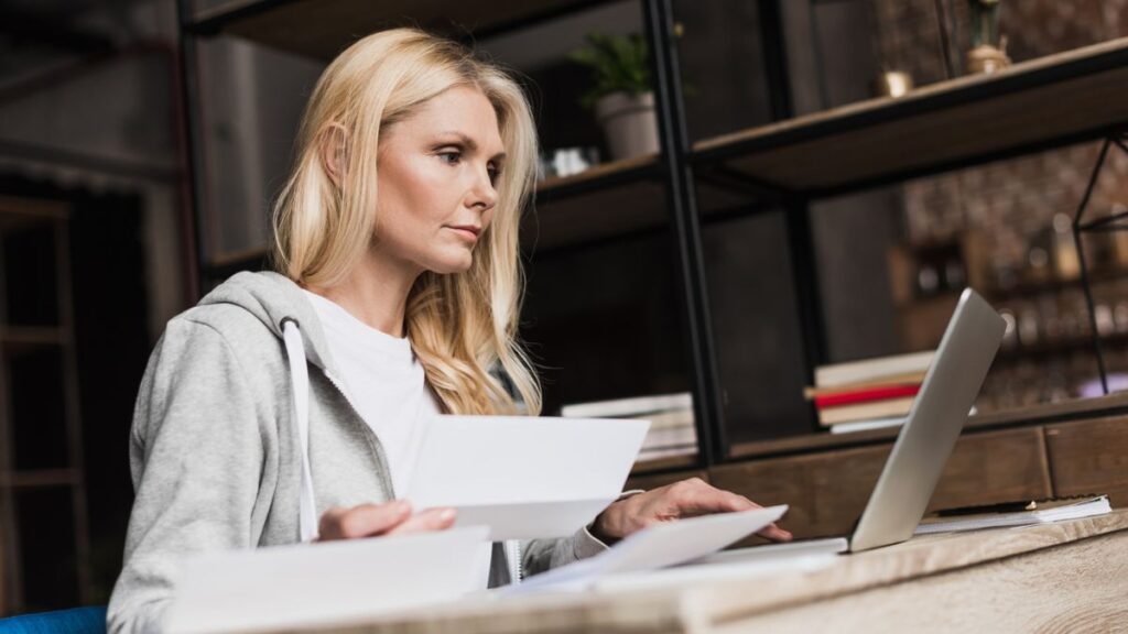 Woman Checking Bills And Using Laptop