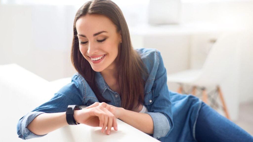 Young Woman Looking At Her Wristwatch Smiling